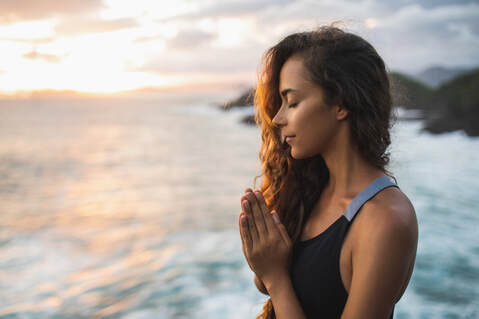 Picture of person in prayer by beach